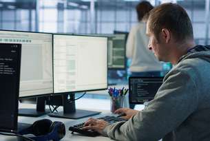 it-programmer-arriving-work-data-center-sitting-pc-desk